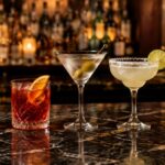 Old Fashioned, Negroni, Dry Martini, Margarita y Mojito sobre la barra de un bar de cócteles
