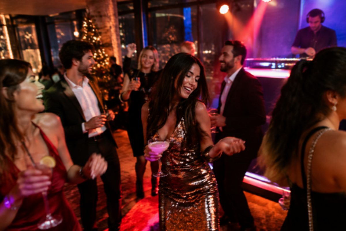 Compañeros bailando con cócteles en la fiesta posterior a una cena de empresa de Navidad